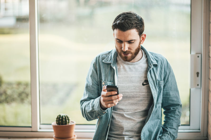 Mobile-Friendly Websites Matter : A man looking at a cell phone.